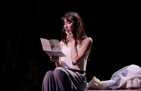 Photo 3 : Une femme seule sur scène en train de lire une lettre
